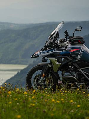 BMW Motorrad auf einer Wiese vor dem Hintergrund eines Flusstals.