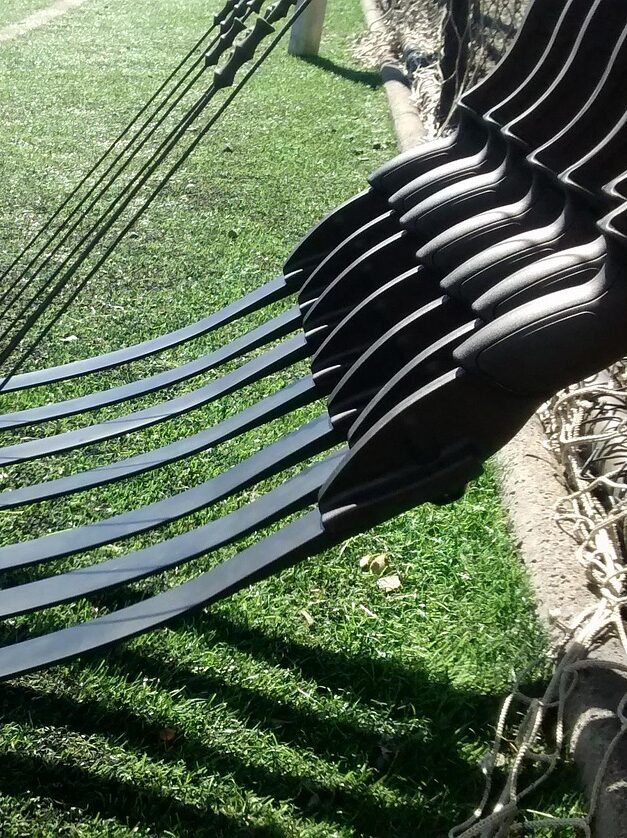 Schwarze Hängematte aus Gewebe, aufgespannt im sonnigen Garten.