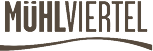 Logo des "Mühlviertel" mit gestyltem Schriftzug in Brauntönen auf grauem Hintergrund, verziert mit gelben und roten Punkten.